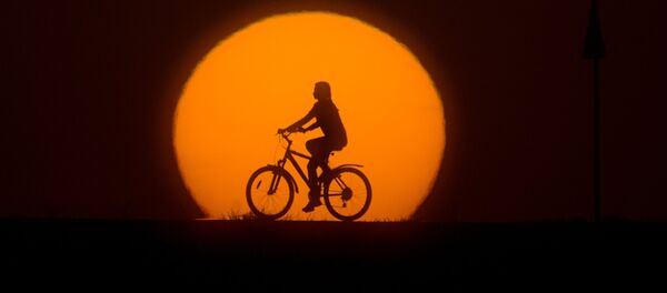Девушка катается на велосипеде на закате Девушка катается на велосипеде на закате - Sputnik Латвия