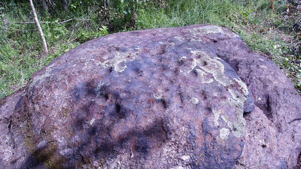 Ритуальный камень в Латгалии с массой рукотворных выемок, наверное, для свечей - Sputnik Латвия