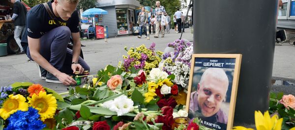 Мужчина зажигает свечу на том месте, где журналист Павел Шеремет был убит в результате взрыва - Sputnik Латвия