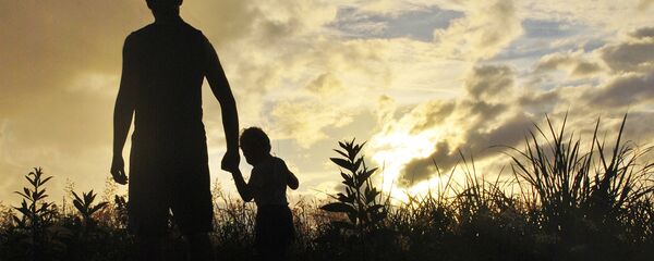 Pieaugušais un bērns saules rietā. Foto no arhīva Pieaugušais un bērns saules rietā. Foto no arhīva - Sputnik Latvija