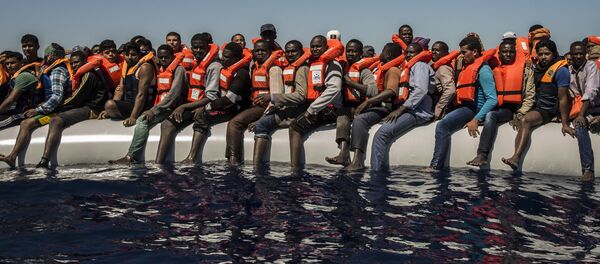 Беженцы ждут спасательную шлюпку в Средиземном море Беженцы ждут спасательную шлюпку в Средиземном море - Sputnik Latvija