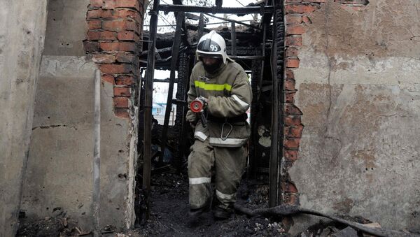 Сотрудник пожарной охраны на месте пожара - Sputnik Латвия