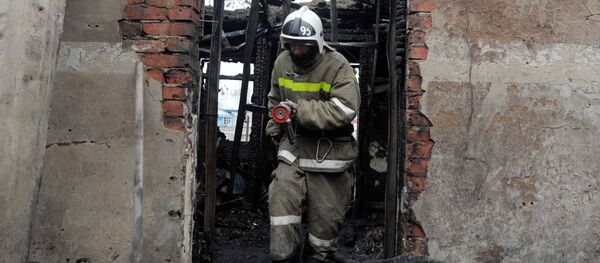 Сотрудник пожарной охраны на месте пожара - Sputnik Латвия