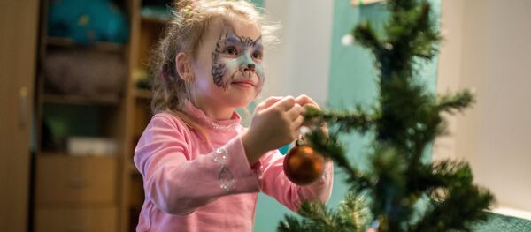 Девочка наряжает новогоднюю ёлку - Sputnik Латвия