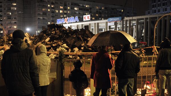 Горожане возлагают цветы и зажигают свечи на месте трагедии в Риге - Sputnik Латвия