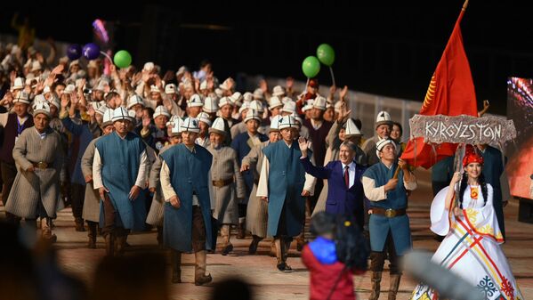 Kirgizstānā izlases pārstāvji ar Kirgizstānas prezidentu Almazbeku Atambajevu priekšgalā 2. Vispasaules nomadu spēļu atklāšanas ceremonijā. Spēles notiek Čolponatas pilsētā Kirgizstānā. - Sputnik Latvija