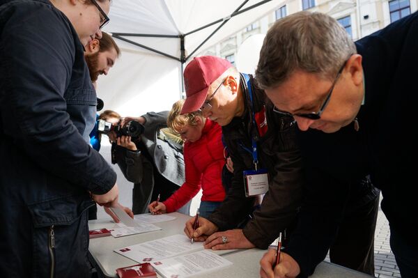 Сбор подписей под обращением к депутатам 12 Сейма. Подписывает руководитель профсоюза медиков Валдис Керис (в кепке) - Sputnik Латвия