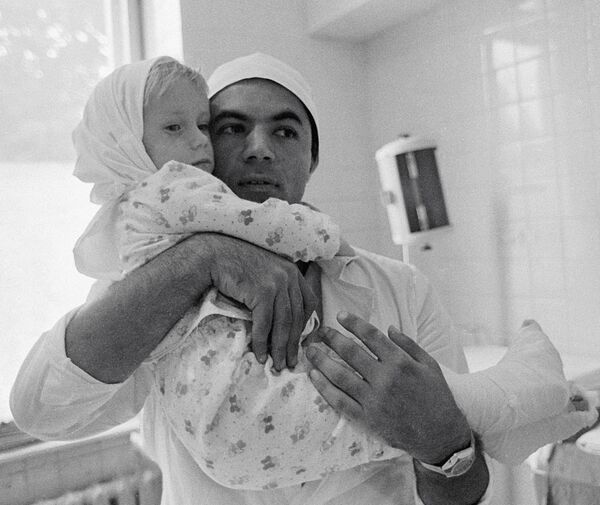 Микрохирург Рамаз Датиашвили держит на руках 3-х летнюю Литовскую девочку Расу Прасцевичуте после успешной операции по реплантации обеих стоп ног - Sputnik Латвия