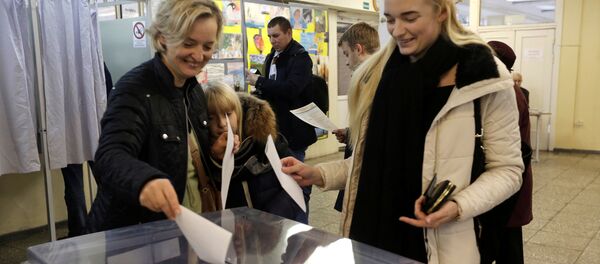 Люди опускают бюллетени в урну на выборах в Вильнюсе, Литва Люди опускают бюллетени в урну на выборах в Вильнюсе, Литва - Sputnik Латвия