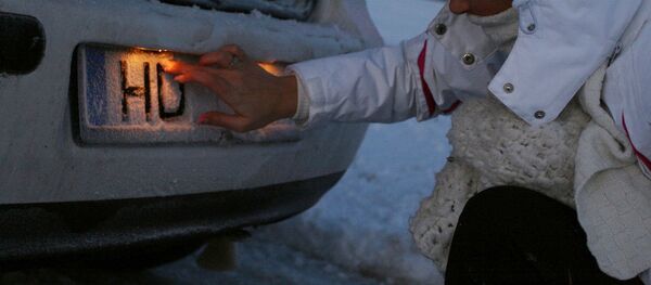 Девушка чистит номер автомашины от снега - Sputnik Латвия