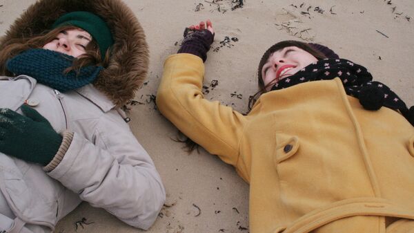 Девушки на пляже в зимней одежде - Sputnik Latvija