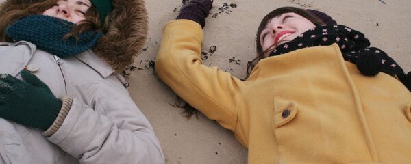 Девушки на пляже в зимней одежде - Sputnik Латвия