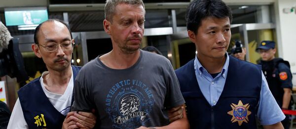 Тайваньские полицейские конвоируют задержанного латвийца Андрейса Перегудовса - Sputnik Латвия