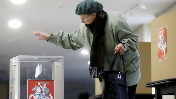 Женщина опускает бюллетень в урну для голосования в Биржае, Литва Женщина опускает бюллетень в урну для голосования в Биржае, Литва - Sputnik Латвия