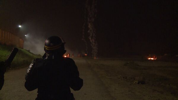 Слезоточивый газ, дым и огонь  –  столкновения полиции и мигрантов в Кале - Sputnik Латвия