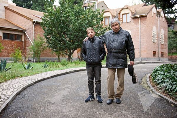 Михаил Уркевич вместе со своим сыном на территории Евангелическо-лютеранской церкви в столице Грузии - Sputnik Латвия