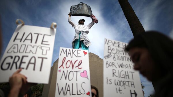 Люди с плакатами во время шествия и митинга против избрания республиканца Дональда Трампа в качестве президента США - Sputnik Латвия