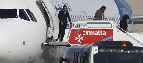 Люди высаживаются из захваченного Airbus А320 авиакомпании Afriqiyah Airways на взлетной полосе в аэропорту Мальты - Sputnik Латвия