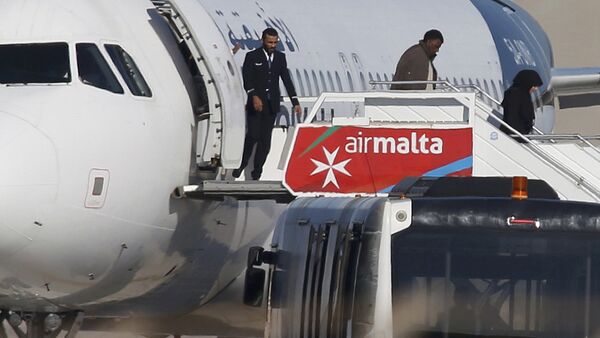Люди высаживаются из захваченного Airbus А320 авиакомпании Afriqiyah Airways на взлетной полосе в аэропорту Мальты - Sputnik Латвия