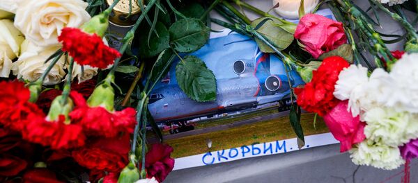Рижане несут цветы и свечи к зданию посольства России в связи с авиакатастрофой Ту-154 над Чёрным морем - Sputnik Латвия