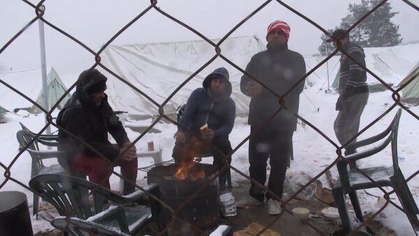 Беженцы грелись у костра в занесенном снегом лагере мигрантов в Салониках - Sputnik Латвия
