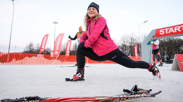 Участница гонки разминается перед стартом Участница гонки разминается перед стартом - Sputnik Латвия