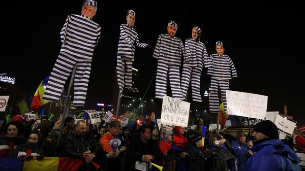 Митингующие держат чучела с лицами лидеров левых социал-демократов Румынии, одетых как узники, во время протестов в Бухаресте - Sputnik Латвия