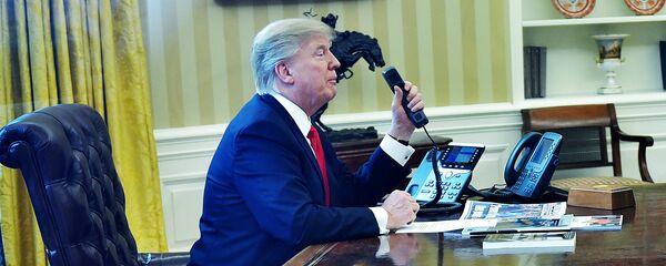 Президент США Дональд Трамп говорит по телефону в овальном кабинете - Sputnik Латвия