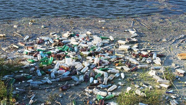 Пластиковые бутылки и другой мусор плавает в воде - Sputnik Latvija