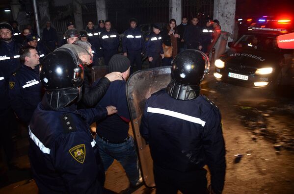 Сотрудники полиции ведут одного из задержанных участников беспорядков в Батуми - Sputnik Латвия