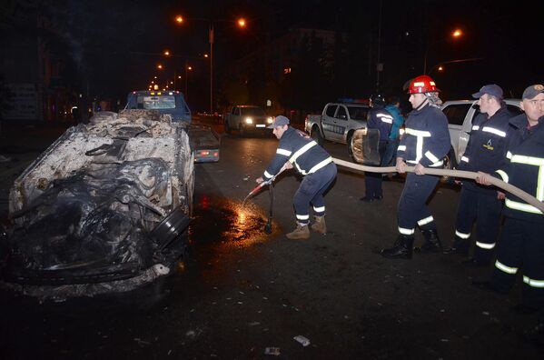 Пожарные тушат один из сожженных в ходе беспорядков в Батуми автомобилей - Sputnik Латвия