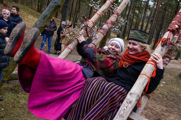 Женщины в национальных костюмах качаются на качелях - Sputnik Латвия