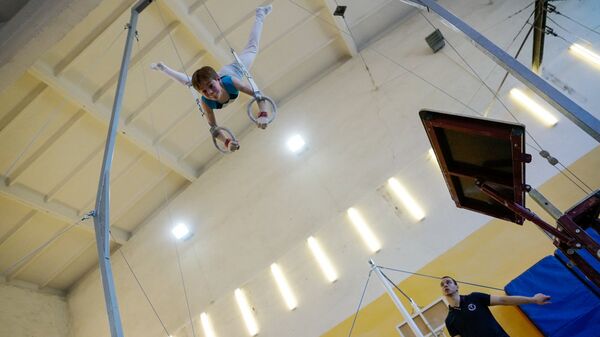 Тренер наблюдает за воспитанником на кольцах - Sputnik Латвия