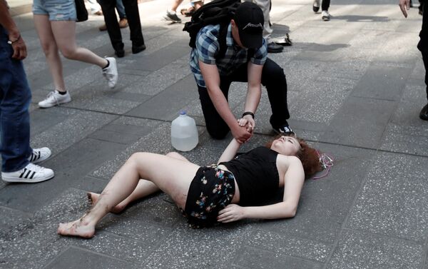 Раненая женщина на тротуаре после наезда автомобиля на толпу пешеходов на Таймс-сквер в Нью-Йорке 18 мая 2017 года - Sputnik Латвия