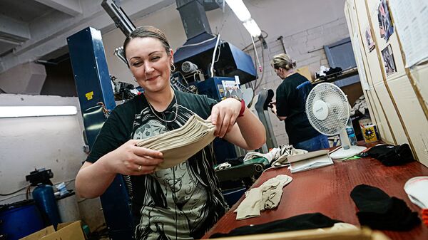 Девушка упаковывает продукцию носочной фабрики - Sputnik Латвия