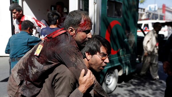 Афганский мужчина несет раненого в больницу после взрыва в Кабуле, Афганистан - Sputnik Латвия