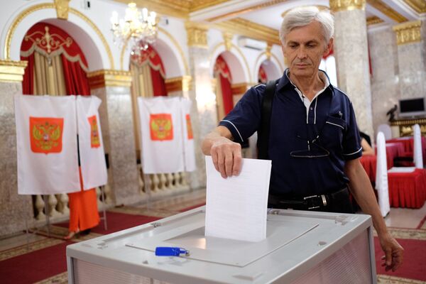 Krasnodaras iedzīvotājs vēlēšanu iecirknī sākotnējās balsošanas laikā partijas Vienotā Krievija kandidātu atlases pasākumā, 2017 - Sputnik Latvija