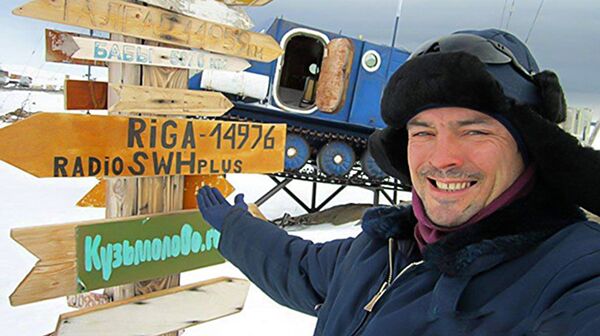 Герман Москвитин рядом с местным указателем направлений - Sputnik Латвия