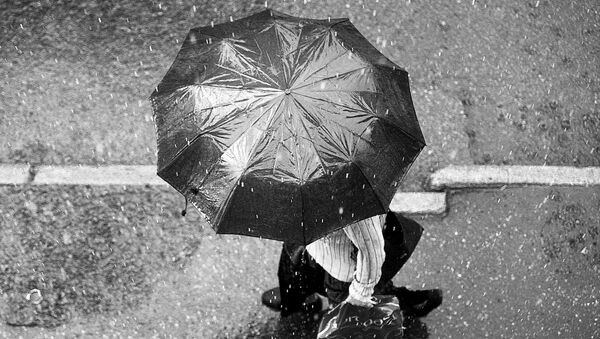 Человек с зонтиком под дождем - Sputnik Латвия