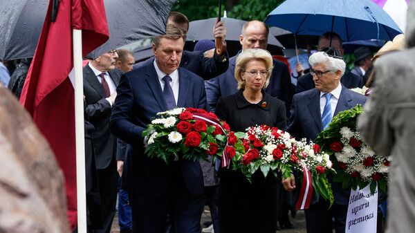 Премьер-министр Латвии Марис Кучинскис, спикер Сейма Инара Мурниеце и председатель Рижской еврейской общины Аркадий Сухаренко возлагают цветы к мемориалу Большой хоральной синагоги - Sputnik Латвия