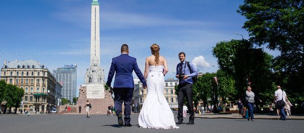 Жених с невестой идут к Памятнику Свободы Жених с невестой идут к Памятнику Свободы - Sputnik Latvija