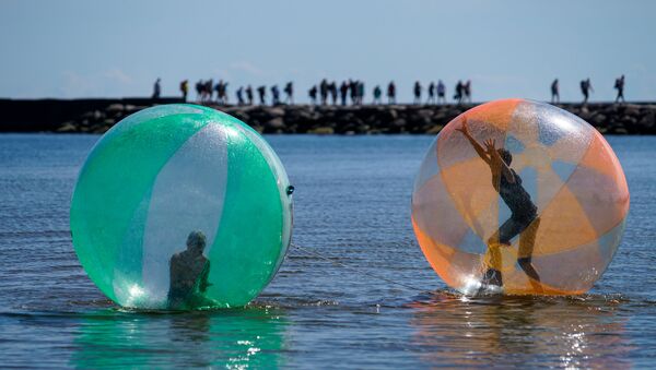 Дети в надувных шарах (аквазобрах) развлекаются на море - Sputnik Латвия