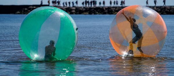 Дети в надувных шарах (аквазобрах) развлекаются на море Дети в надувных шарах (аквазобрах) развлекаются на море - Sputnik Latvija