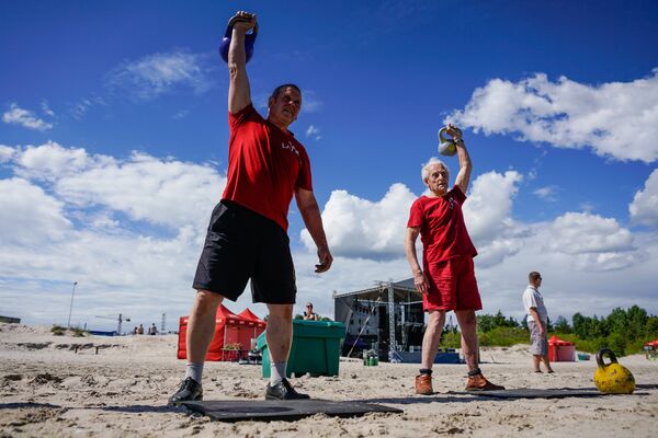 Гаргурнис Виестурс, который является 110-кратным чемпионом мира по гиревому триатлону в своей возрастной категории и 92-летний  Паулис Гилис показывают свое мастерство - Sputnik Латвия