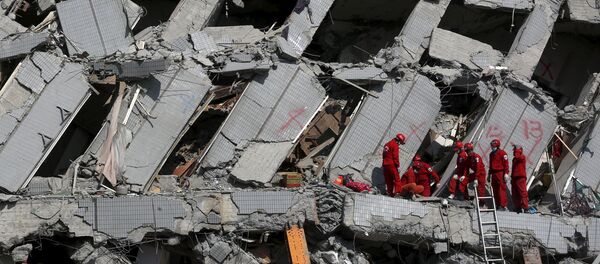 Спасатели работают на месте рухнувшего 17-этажного жилого дома в Тайнань - Sputnik Латвия