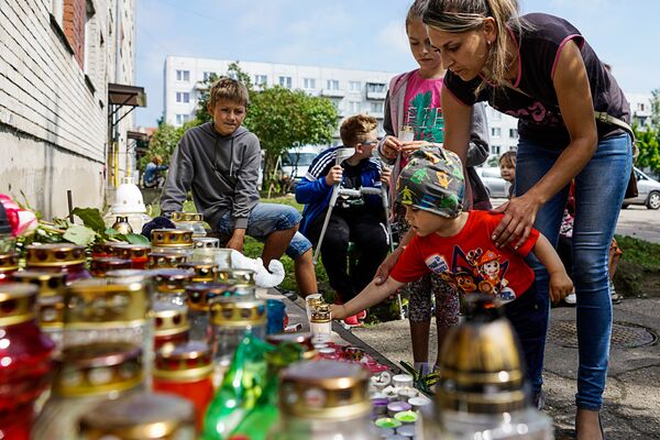 Pieaugušie un bērni nes ziedus, sveces un rotaļlietas mazā Vaņas piemiņai - Sputnik Latvija