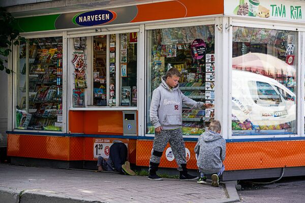 Дети ищут мелочь у киоска в Лиепаи Дети ищут мелочь у киоска в Лиепаи - Sputnik Латвия