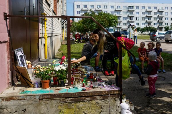 Liepājas iedzīvotāji noliek ziedus un rotaļlietas pie Vaņas kāpņu telpas durvīm - Sputnik Latvija