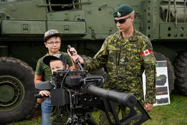 Военнослужащий Канады демонстрирует детям автоматический гранатомёт - Sputnik Латвия