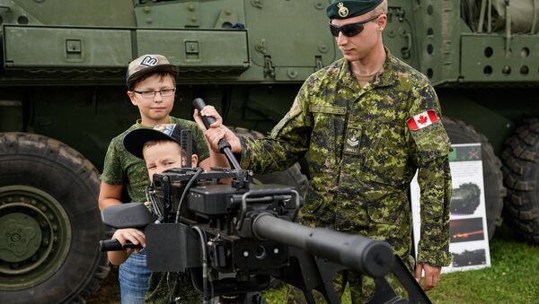 Kanādas karavīrs demonstrē bērniem automātisko granātmetēju - Sputnik Latvija